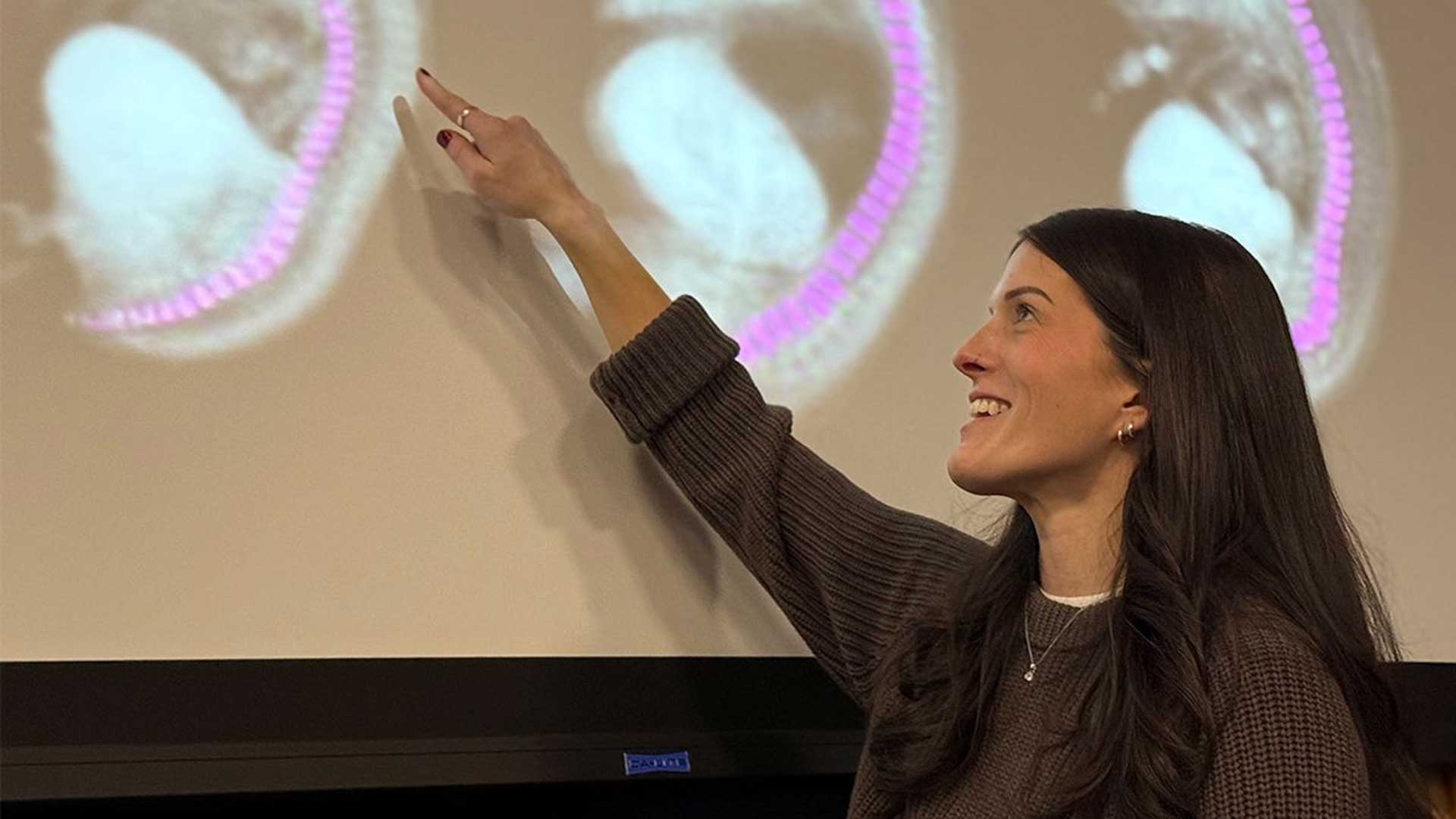 Becca Coltogirone points to an image on the wall