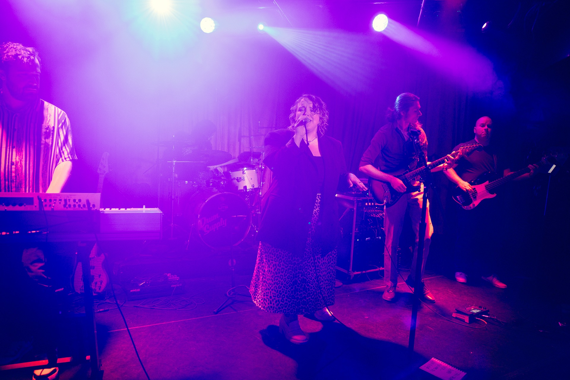 Sarah Giles singing on stage with band