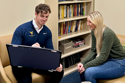 Two people talking. One is drawing on a small whiteboard.