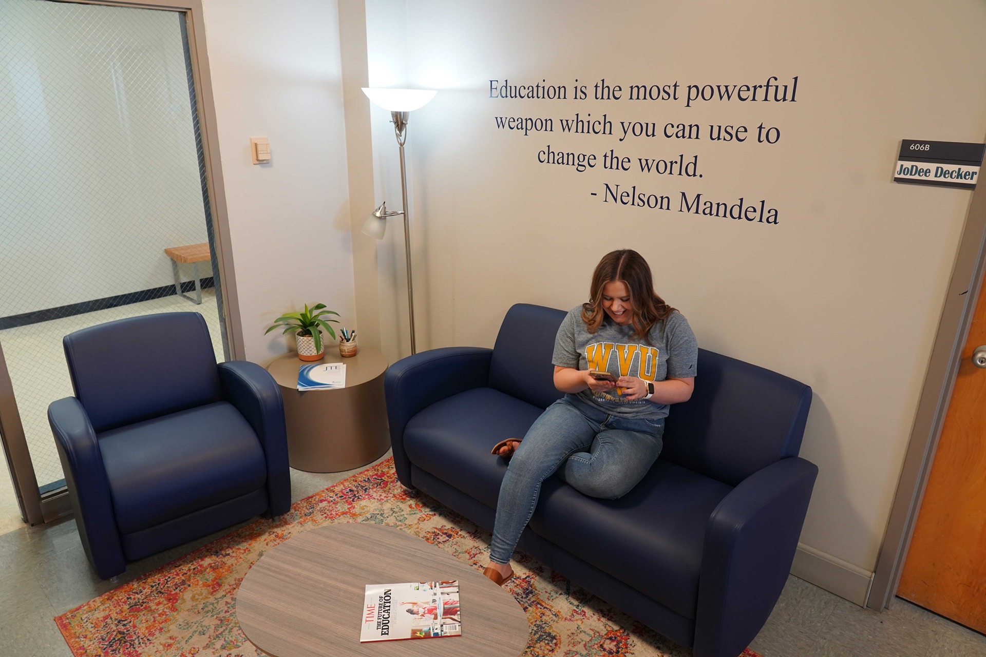Student sitting on a blue sofa in the Allen Hall lounge