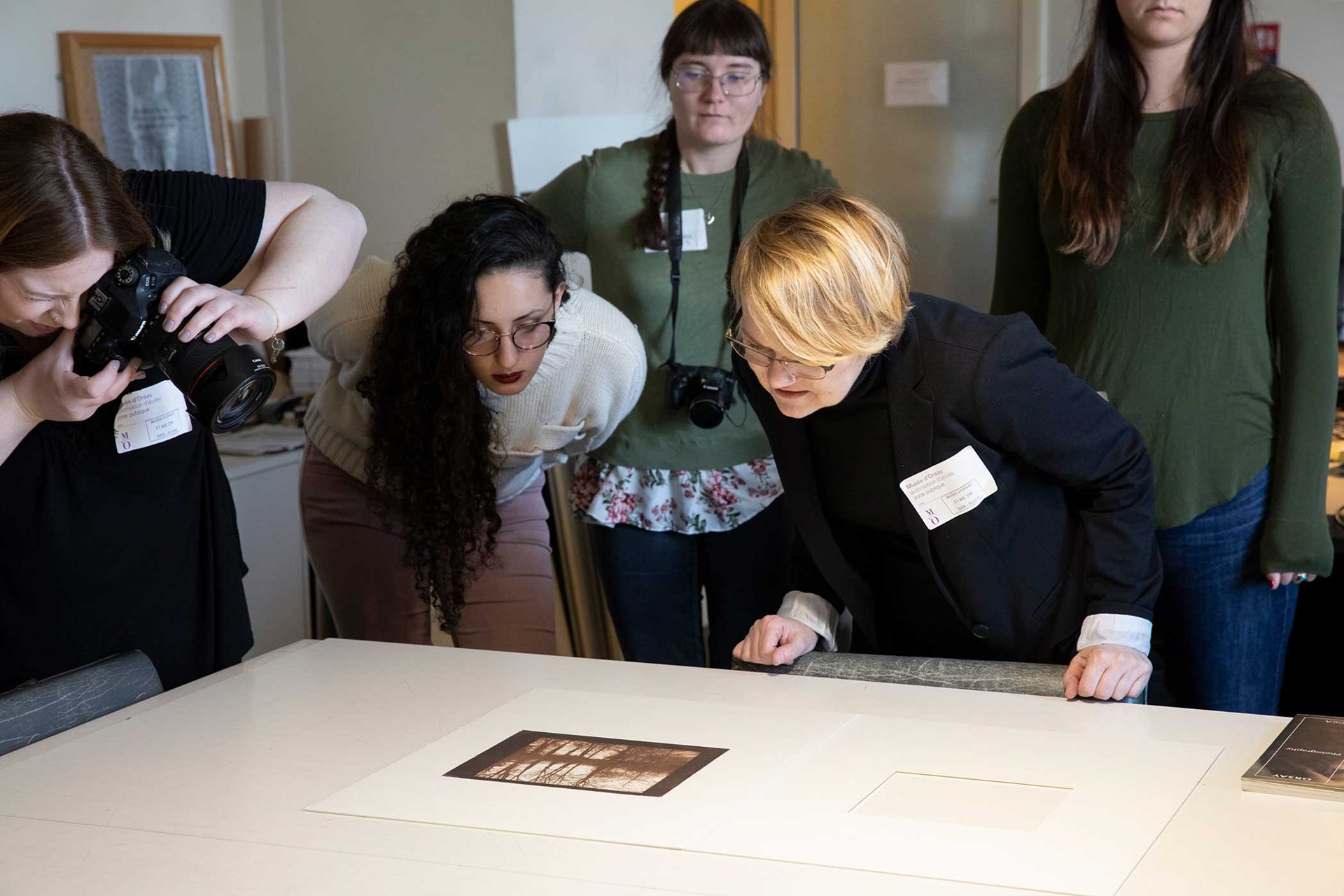 Student examine and photograph an image at Musee d'Orsay.