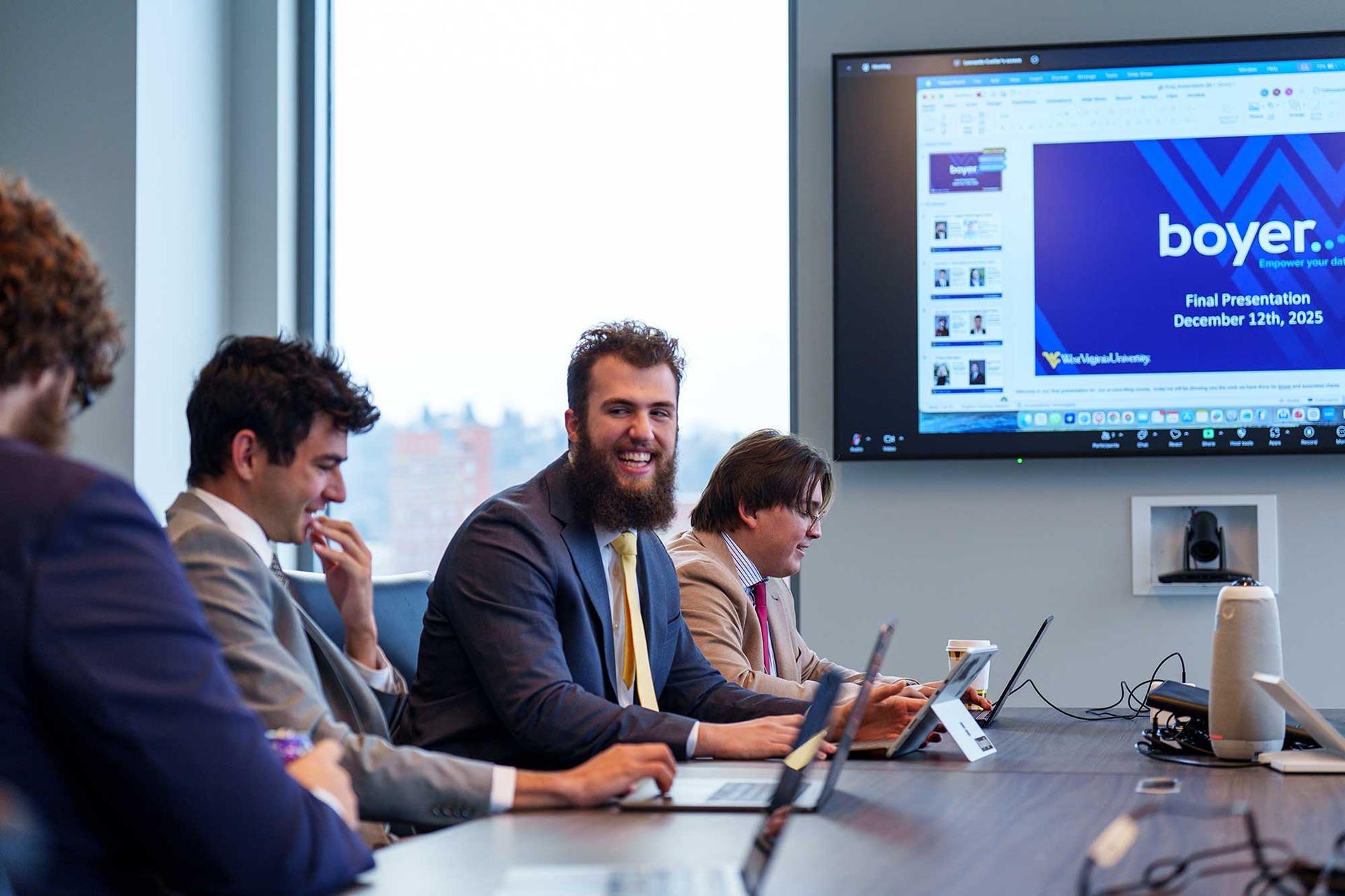 Students seated at a boardroom table discussing a project.