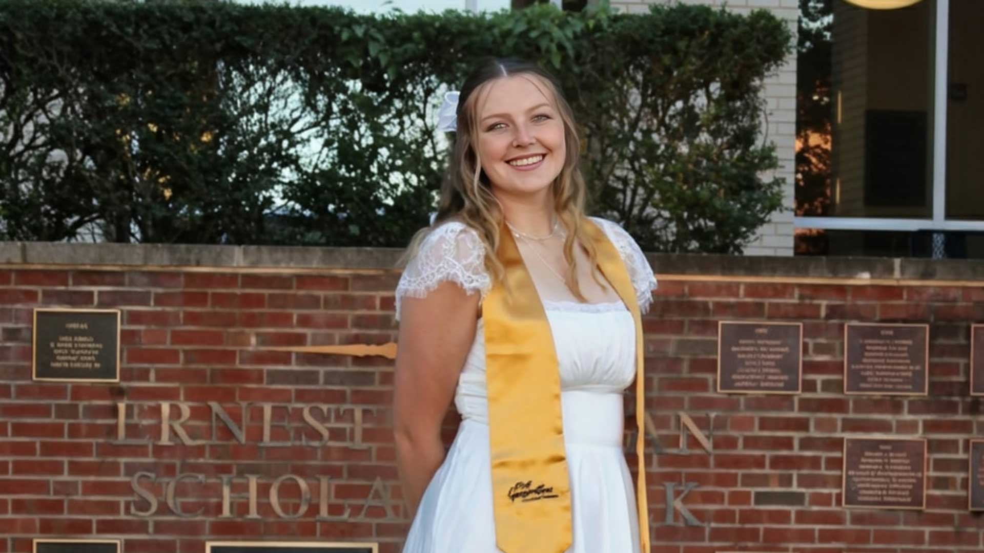 Emily Chittester wearing a gold graduation stole