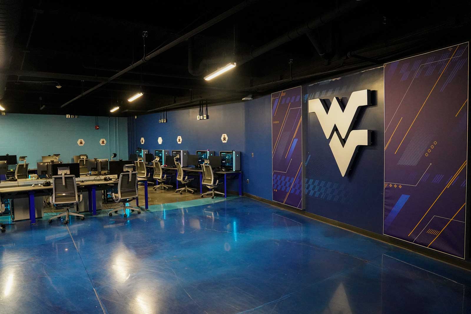A large Flying WV looms over the interior of the WVU Esports Broadcast and Marketing Studio.