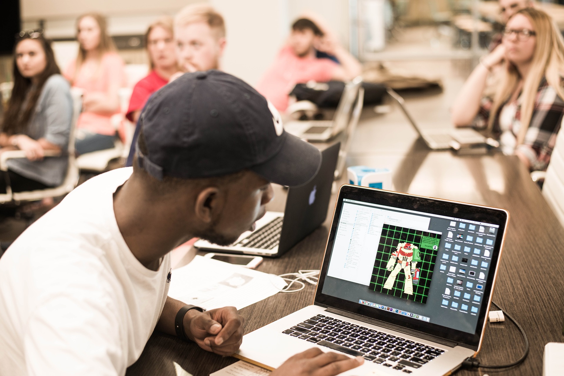 Student with computer screen showing a design for critique.