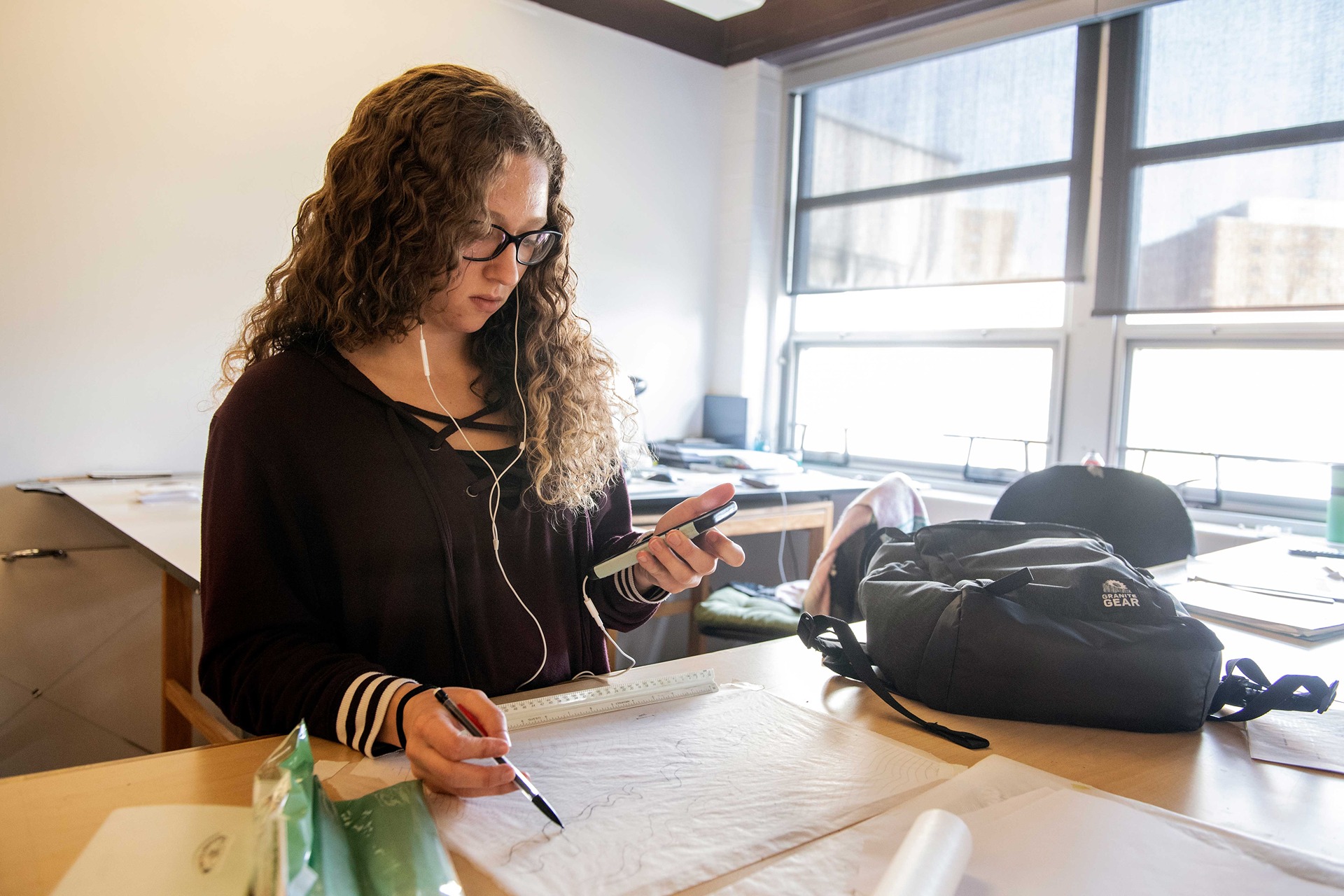 Student drawing in a space filled with natural sunlight.