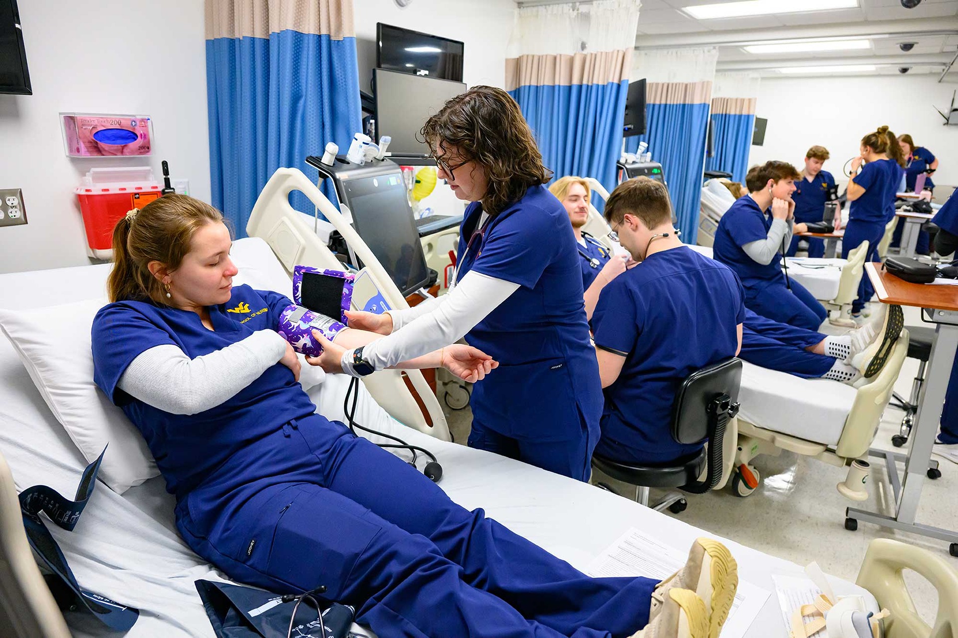 Nursing students practice taking blood pressure in the skills lab