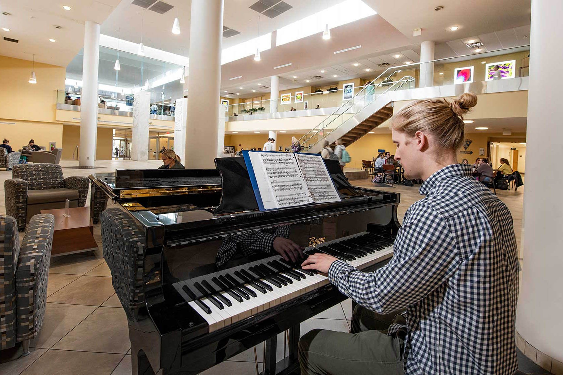 Person playing piano in Health Sciences lobby
