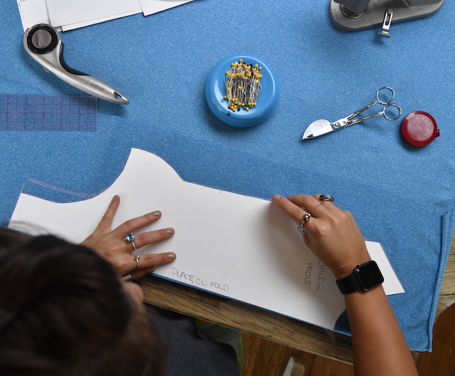 Person tracing a pattern on fabric