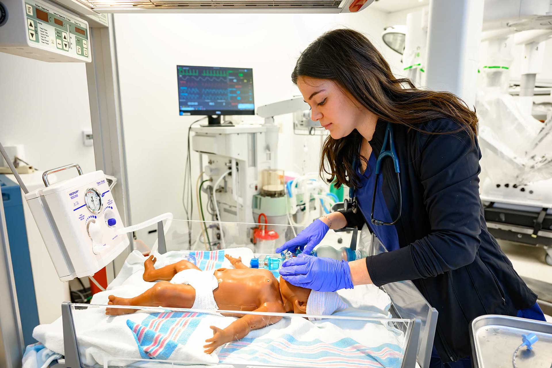 Respiratory therapy student practices on an infant manikin in the STEPS Center