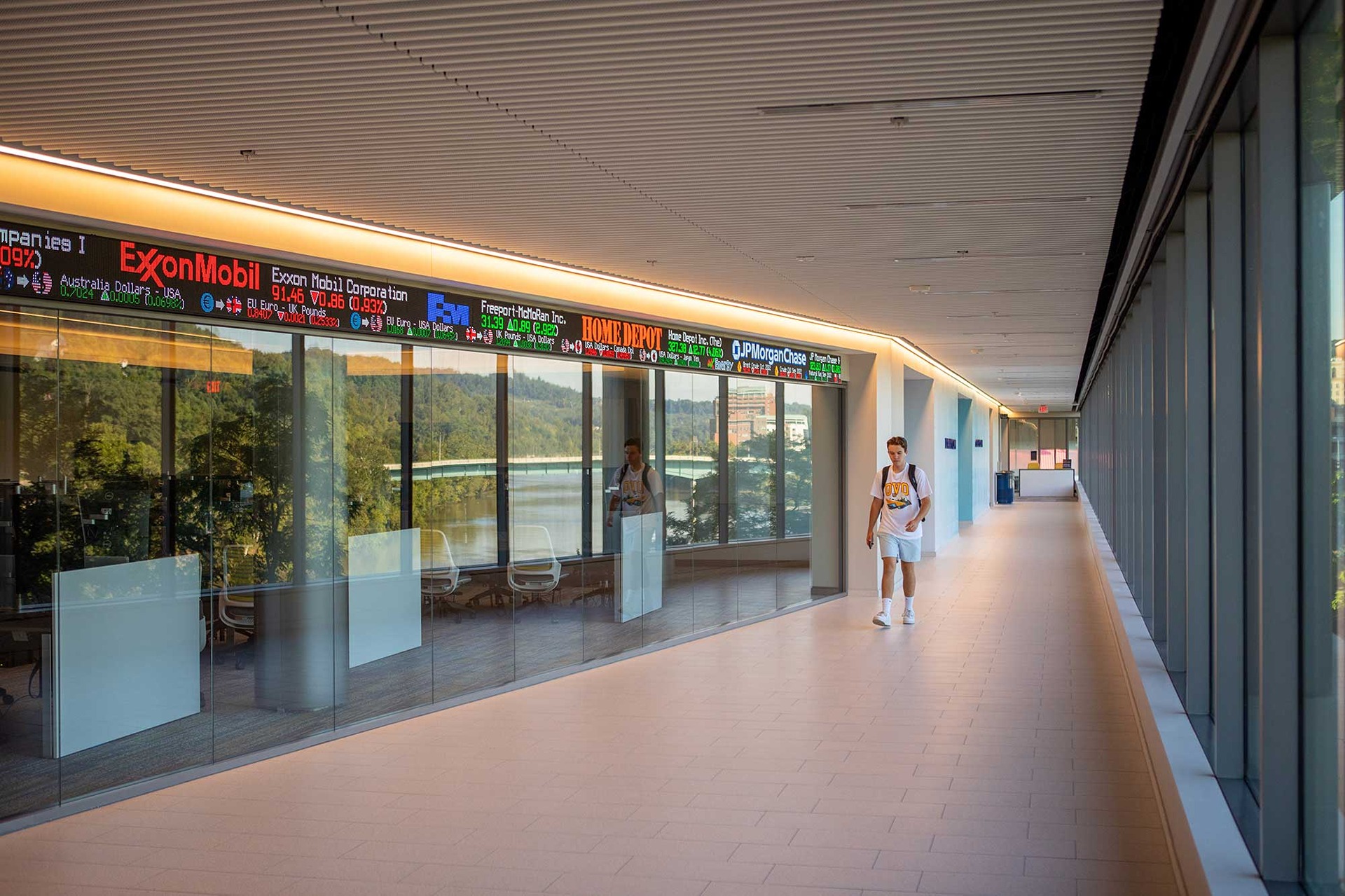 A student walks by the live stock ticker display in Reynolds Hall