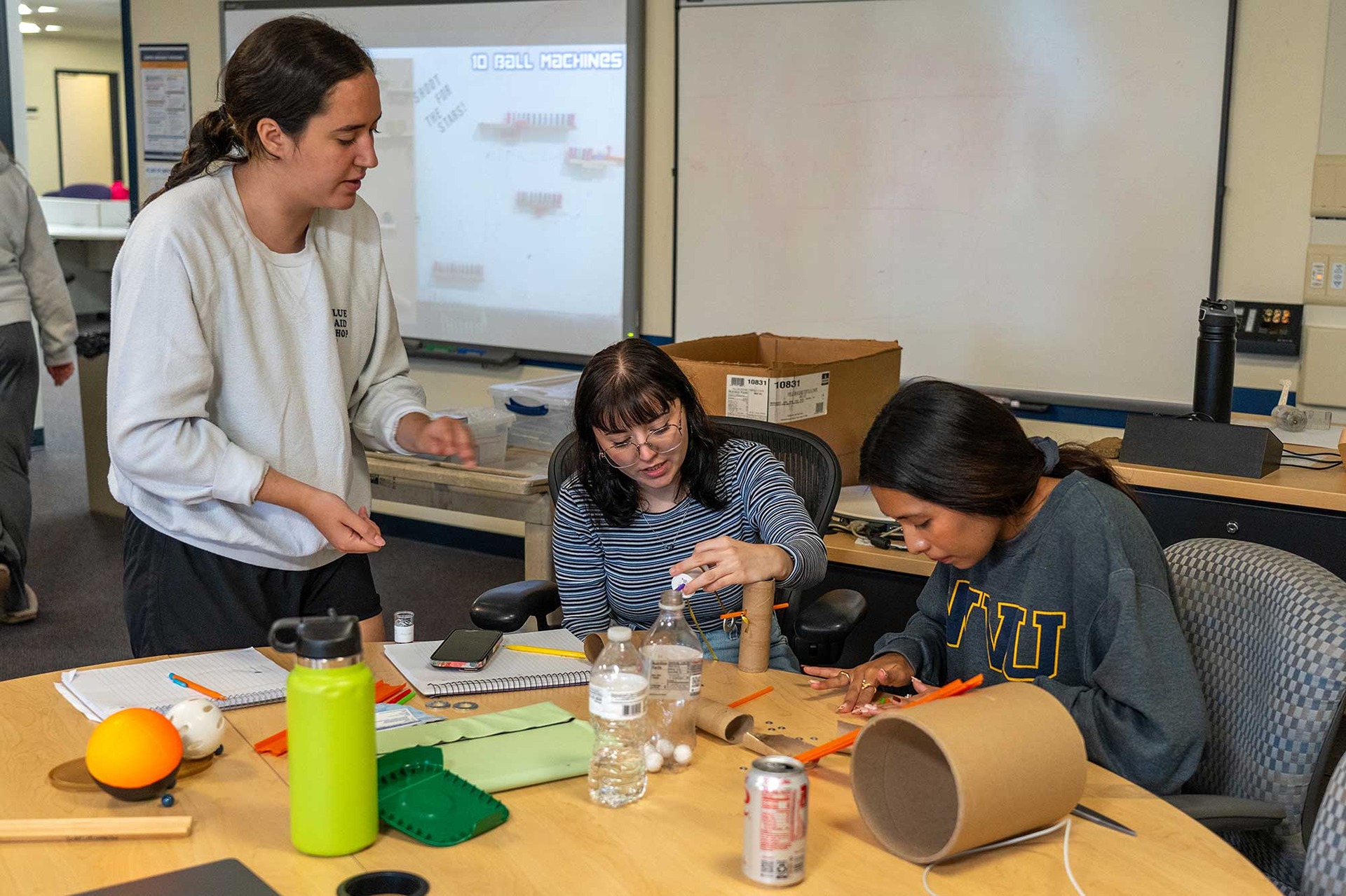 Education students build a learning aid from cardboard tubes.