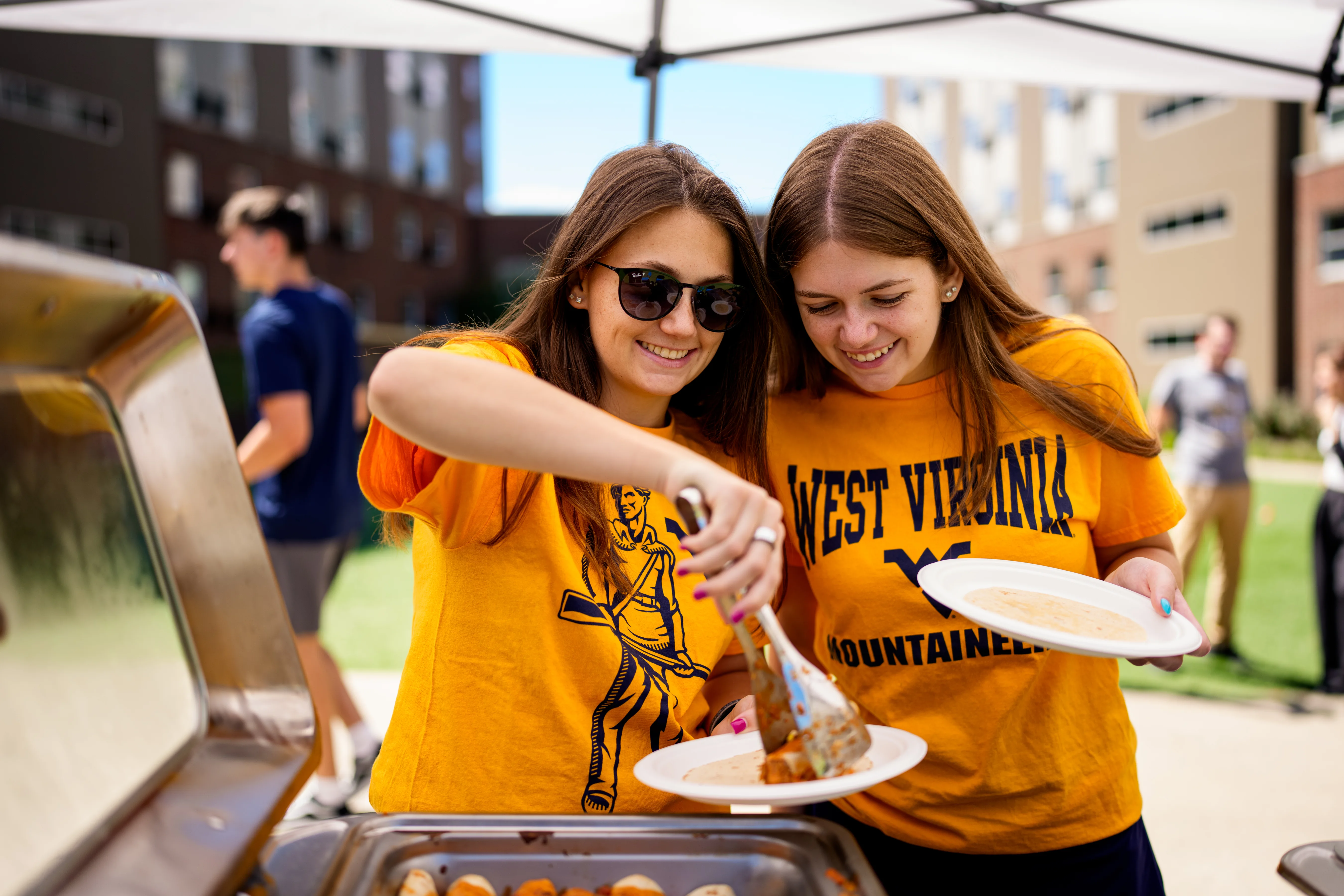 two students getting food at the student lot tailgate
