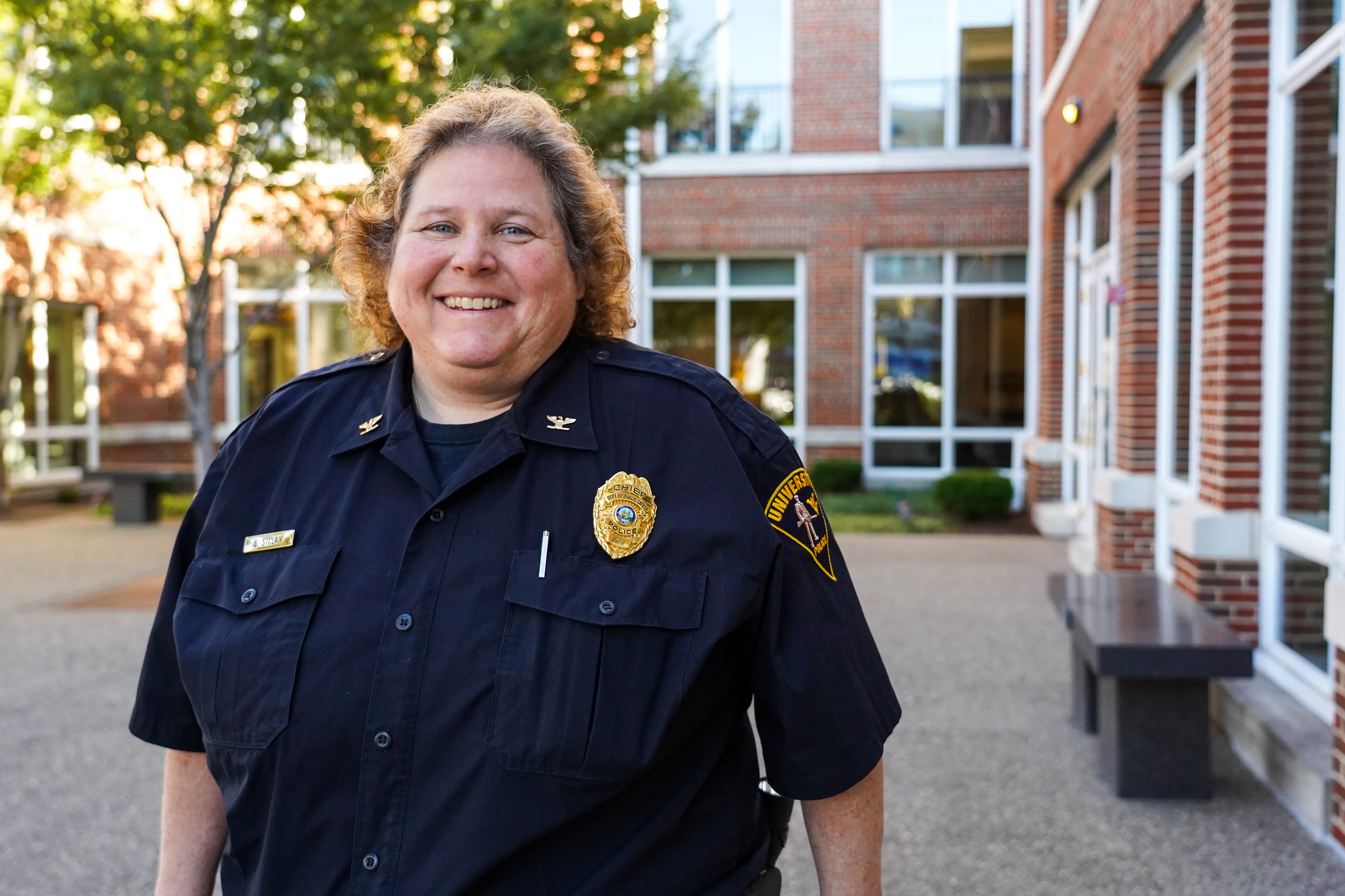WVU Police Chief Sherry St. Clair smiles outside the Erickson Alumni Center on a sunny day