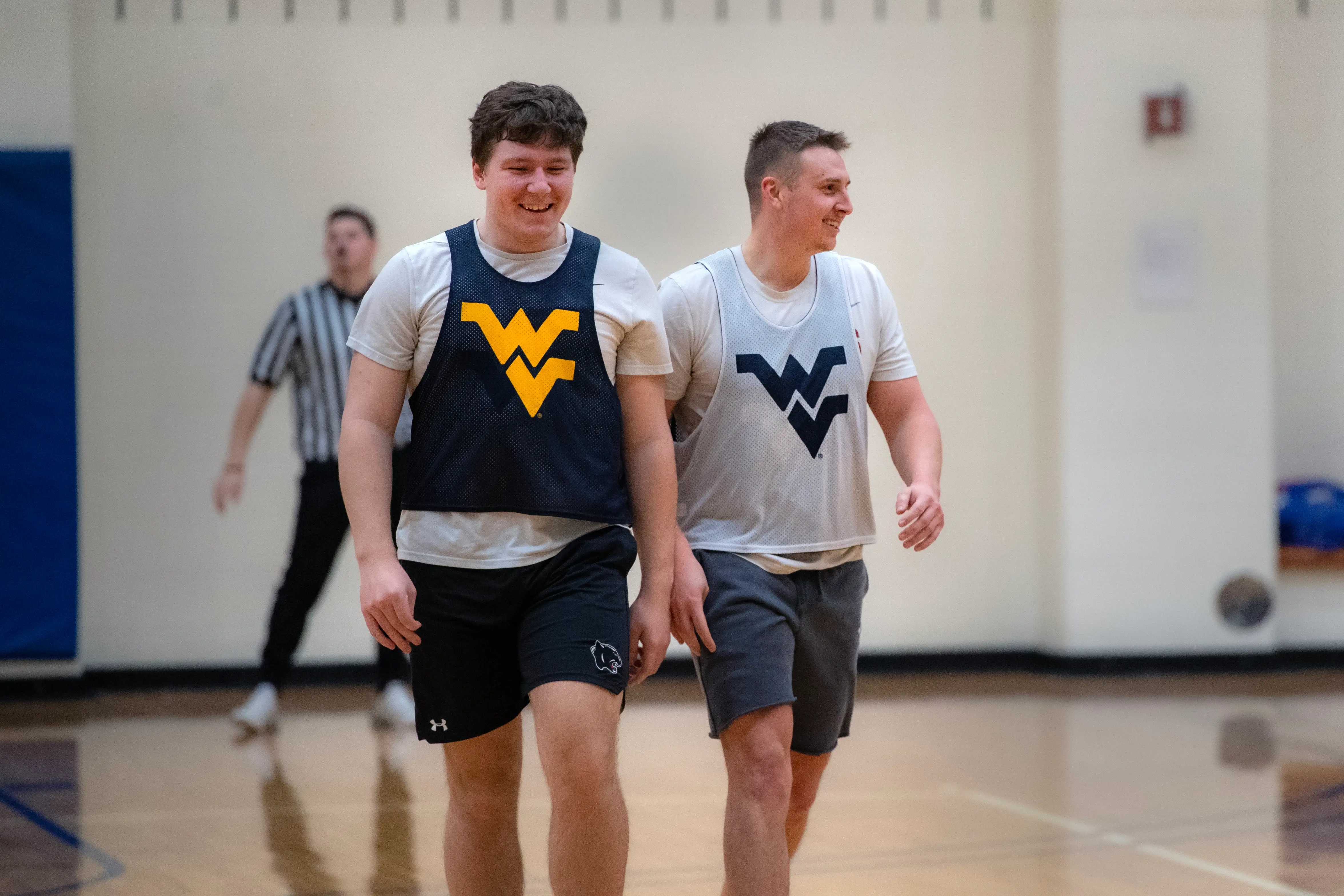 Two students wearing WVU jerseys playing basketball