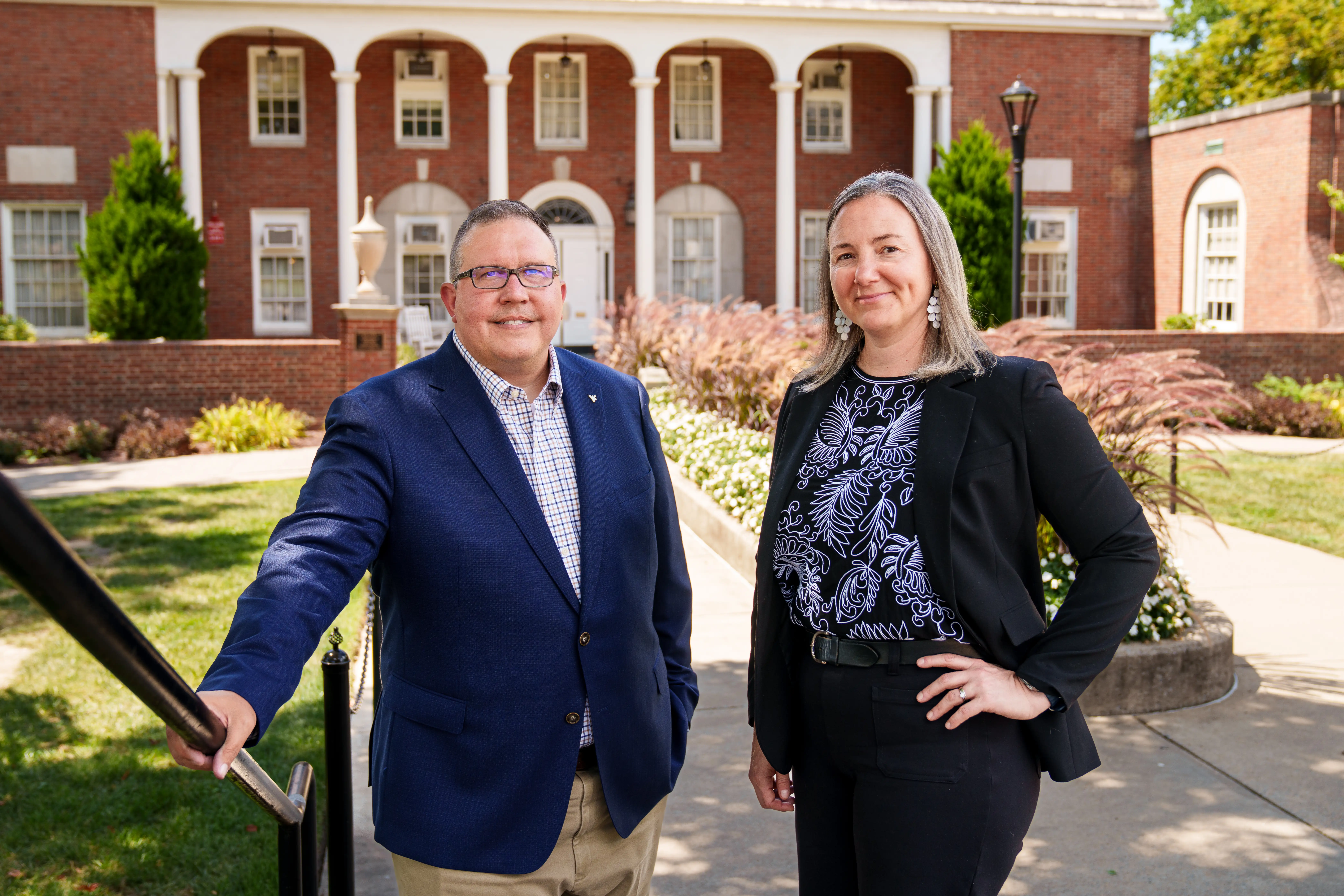 Gary G. Furbee II and Carrie Showalter stand side by side in front of E. Moore Hall on a sunny day.