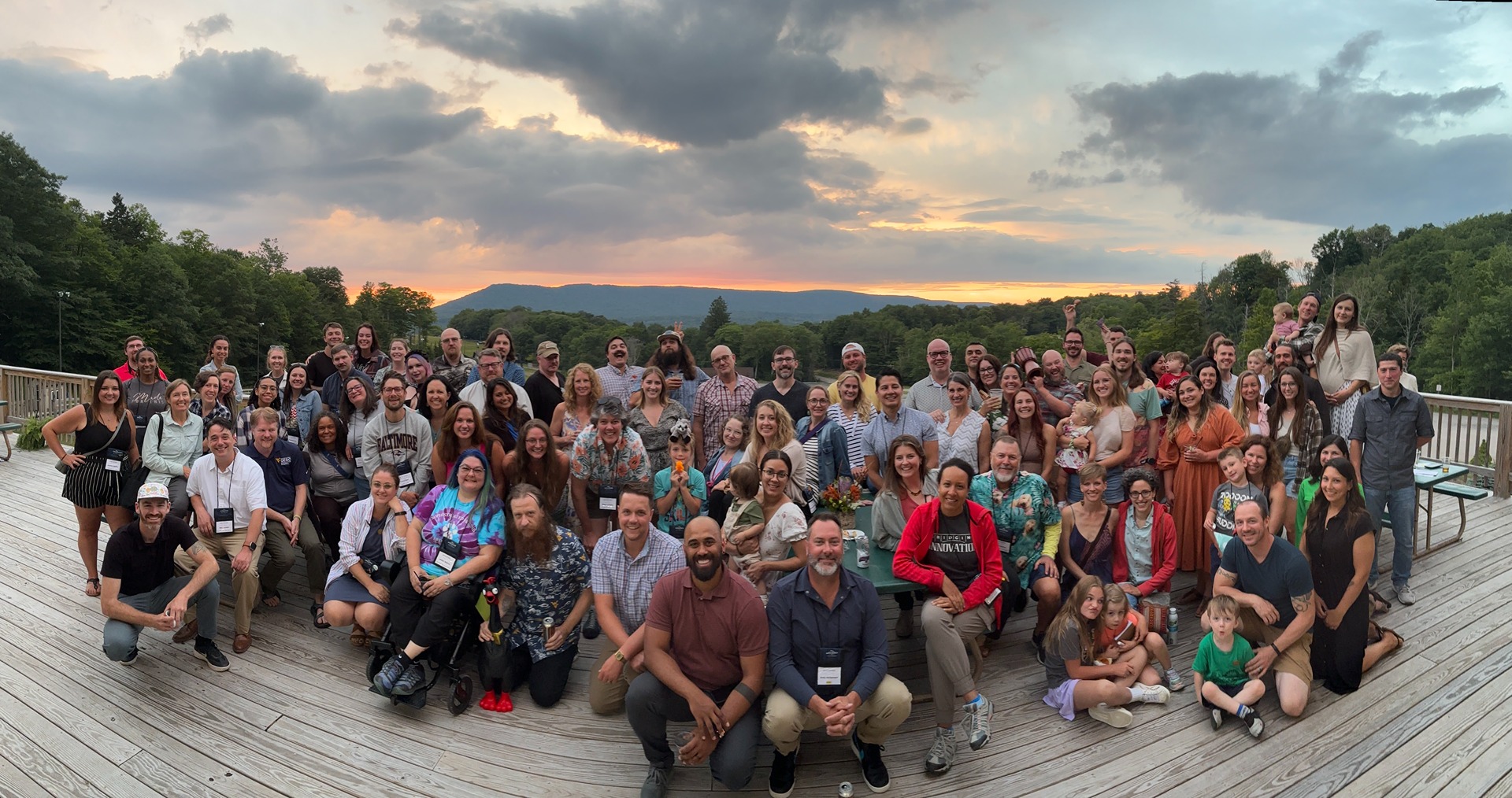 Ascend WV, First Ascent and Teachers Ascend members gather on an outdoor deck with mountains in the background.